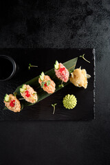 Elegant spicy sushi assortment with salmon, shrimp, tuna, and eel, top view on dark slate