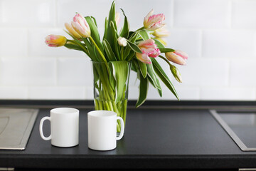 Pink tulips bouquet in glass vase on the kitchen