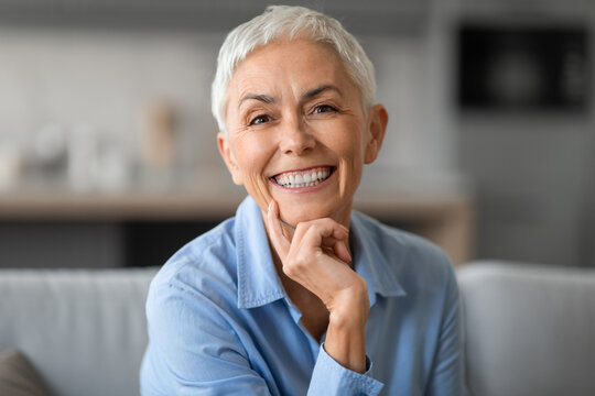Portrait of lovely older woman smiling to camera touching chin