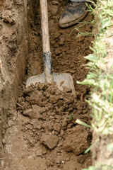 A man shovels a trench for drainage and sewage.