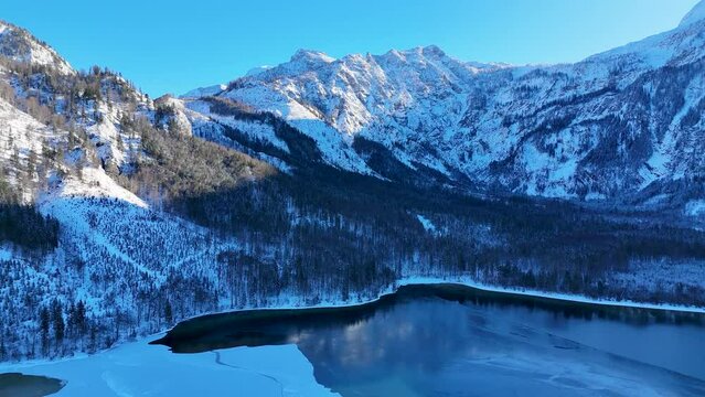 Drohnenflug &uuml;ber dem See in den Bergen in sch&ouml;ner Landschaft im Winter im Salzkammergut