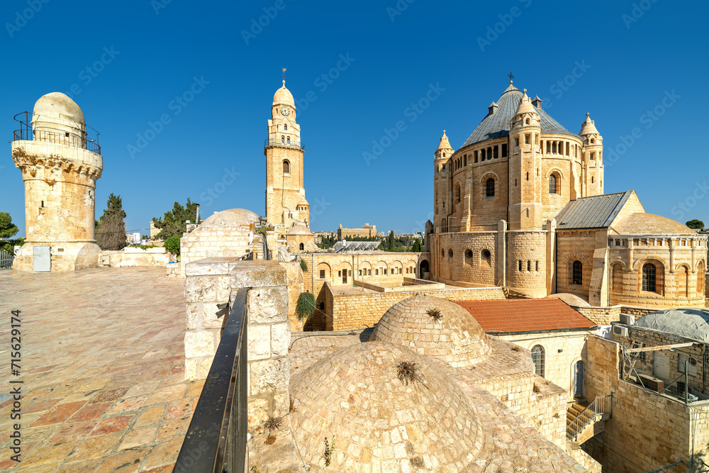 Wall mural dormition abbey, minaret and belfry under blue sky over the old roofs of jerusalem, israel.