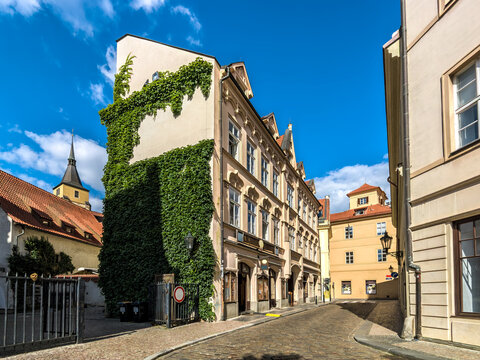 Narrow cobblestone street among houses in old town of Prague.