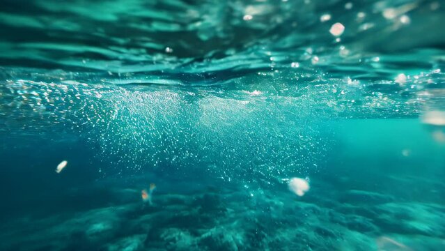 Air bubbles rise beneath the water's surface, mingling with the blueness of the water and the refraction of light.
