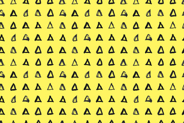 Dash pattern on yellow background. Wrapping paper with small black triangles painted with a brush. Seamless simple minimal ornament. Abstract geometric grunge vector texture painted by ink.
