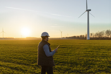 Businessman checking on wind turbine energy production