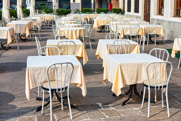Outdoor restaurant terrace with tables and chairs in the city street 