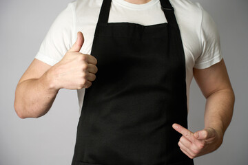 Male chef wearing apron and pointing with hand