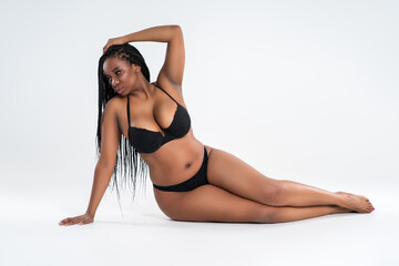 Curvy busty plus size model in underwear on gray background, overweight African black woman in sexy lingerie, fat body - obrazy, fototapety, plakaty