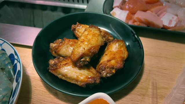 Fried chicken wings with savory sauce on a plate, a delicious and hearty meal