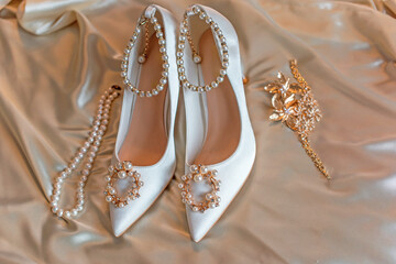 Weddings women white shoes with a heels with a flowers and pearls. Concept of Wedding, accessorize