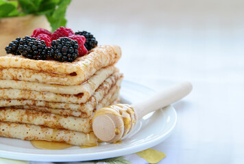 thin French crepe pancakes with fresh berries and honey