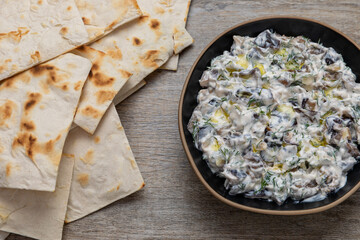 Eggplant with dill and yogurt dip in a bowl and Armenian lavash chips on the table. 