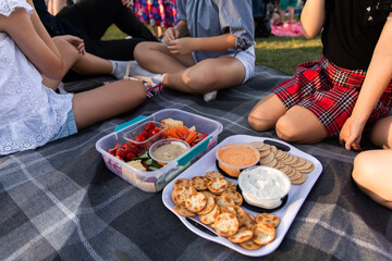 platters of picnic food on a rug in a park