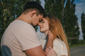 Fototapeta premium Cheerful redhead caucasian girl standing head to head at her boyfriend in love, valentine. Outside, romance, summertime. Honey moon.