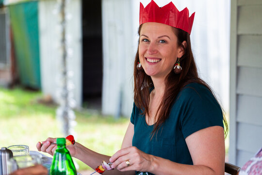 Portrait of a woman in her forties at Christmas lunch table wearing red cracker hat