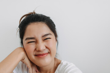 Happy asian Thai woman take selfie and smiling to camera, resting head on hand posting, isolated over white background wall