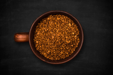 Top view of a cup of instant coffee on a black background, close up