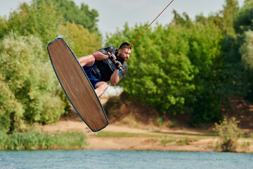 male wakeboarder does a backroll trick