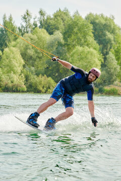 male wakeboarder performs grab trick