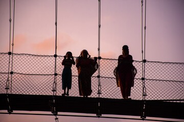 Silhouettes of people at a bridge