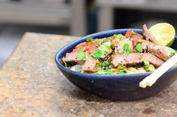 close up view of asian salad nam tok with noodles and beef