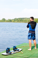 boots in mounts on wakeboarding boards in blue next to a male wakeboarder