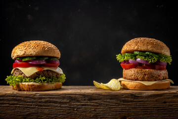 Two fresh tasty burgers on wooden rustic table. Food background.