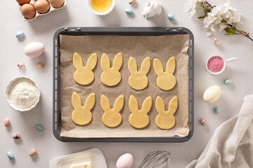 Homemade Easter bunnies shaped cookies in oven tray on white background. Top view. Space for text....
