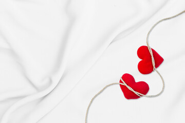 Two red heart on white fabric background, love and romance concept, valentine background idea