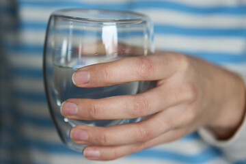 Woman drinks water, Close-up shot of man holding glass of fresh water, Quenching thirst, Lifestyle...