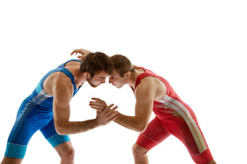 Young skilled wrestlers in blue and red uniform hand wrestling in neutral position on their feet against white studio background. Concept of sport, mixed martial arts, active lifestyle, movement.