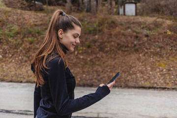 Phone, fitness and woman in nature for training with a mobile app, online workout and marketing exercise on social media. Space, advertising and athlete with a mobile for park sports.