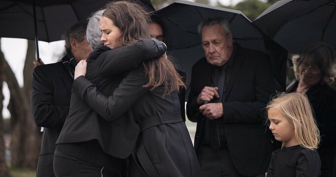 Funeral, crying family and people hug for grief support, mourning depression and death at emotional burial event. Kid child, mom and group together with widow hugging senior mother at coffin ceremony - Powered by Adobe