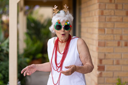 elderly lady with a Christmas surprise dressed up in beads sparkly glasses