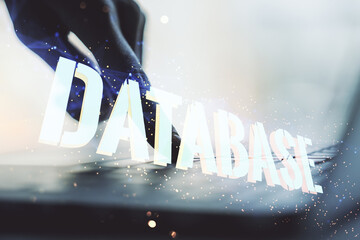 Double exposure of creative Database word hologram and hands typing on laptop on background,...