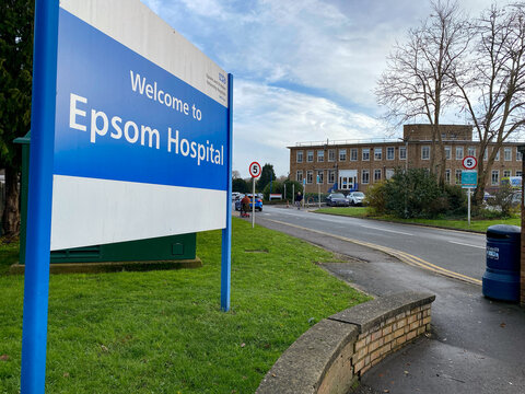 EPSOM, SURREY, UK - Dec 8, 2023: Welcome sign of Epsom Hospital with buildings on the right on a semi-cloudy day
