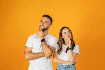Happy pensive young european guy and woman think, look at free space