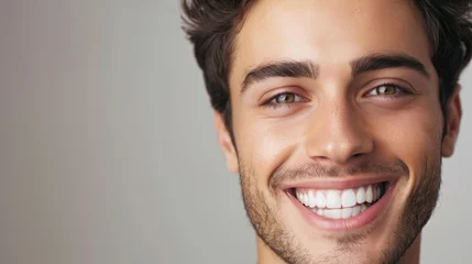 Fotobehang Smiling man on grey background, teeth whitening. © OLGA
