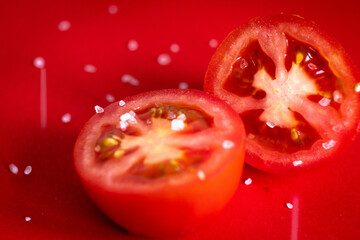 Tomatoes being sprinkled with salt. 