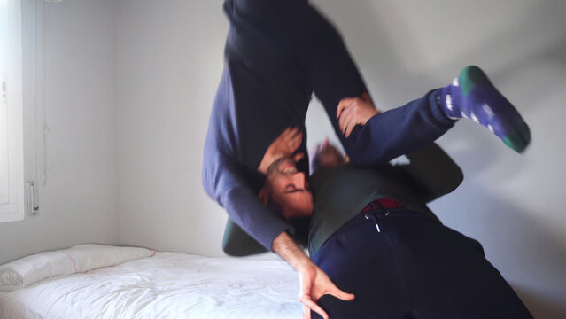 Wrestling at home concept. Young adults do suplex on bed