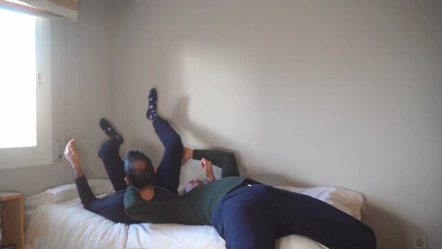 Wrestling at home concept. Young adults do suplex on bed