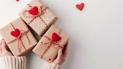 Deurstickers Cadeaux de Saint-Valentin tenus dans des mains féminines sur fond décoré de cœurs © Patrick