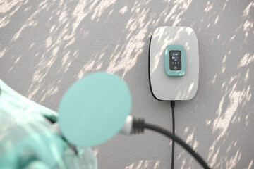 Charging an electric vehicle at home with a home charging station (wallbox). Focus on the wallbox...