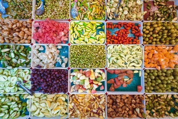 Top view of assorted fruits and pickled fruits on trays for sale in street market, healthy food...