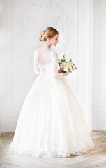 Fototapeta premium Young beautiful blond woman posing in a wedding dress
