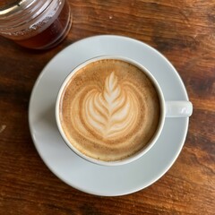 A cup of coffee with a leaf design on it AI Image generate