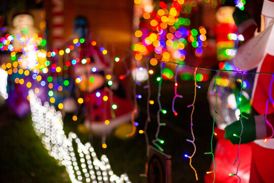 strings of lights and christmas decorations in a front yard display