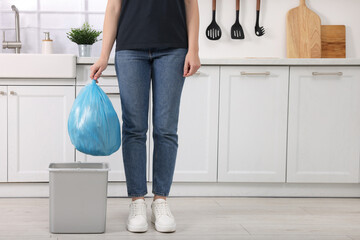 Woman taking garbage bag out of trash bin in kitchen, closeup. Space for text - obrazy, fototapety, plakaty