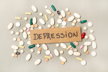 Etiqueta con la palabra depresión junto a pastillas sueltas sobre un fondo gris. Vista superior y de cerca